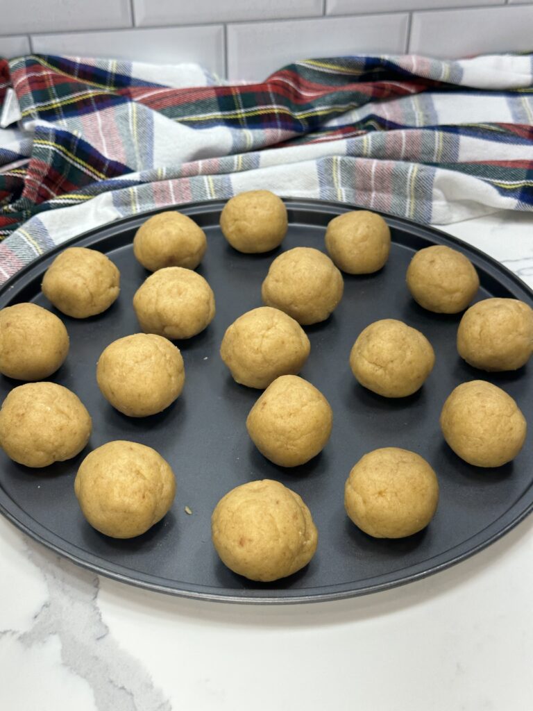 Image of several 1-inch cake pop balls lying on a pan.