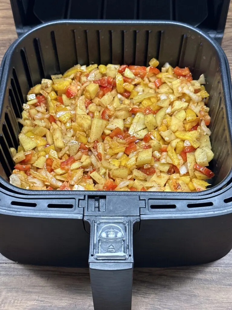 all ingredients of the recipe spread evenly on the air fryer tray