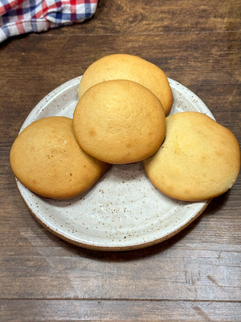 Four soft buttermilk sugar cookies on a plate